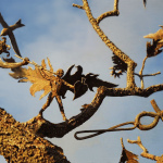 Detail of Winged Figure on Monumental Tree Sculpture.
